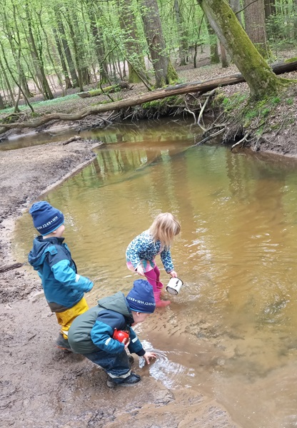 Kinder spielen am Bach